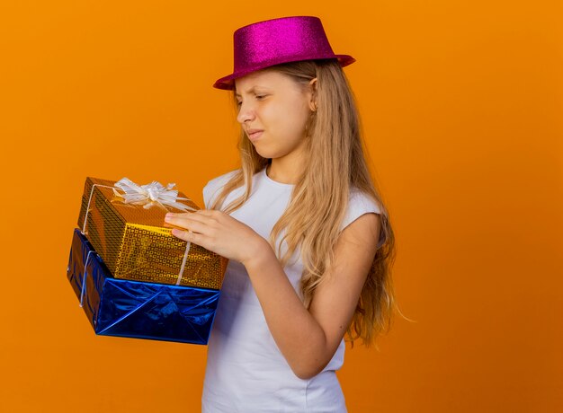 Foto gratuita niña bonita con sombrero de fiesta con cajas de regalo