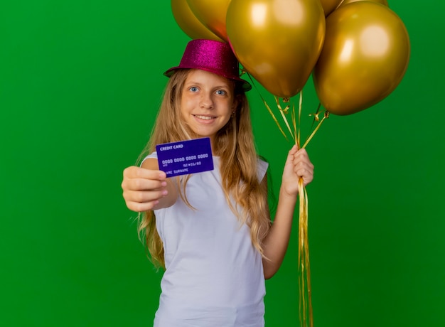 Niña bonita con sombrero de fiesta con cajas de regalo