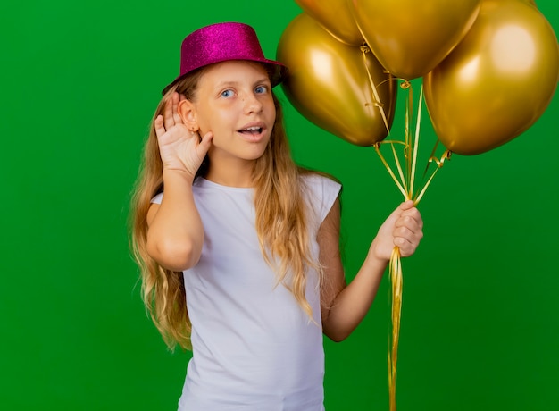 Niña bonita con sombrero de fiesta con montón de globos