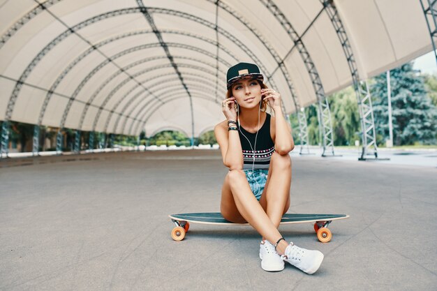 Niña bonita sonriente con un longboard