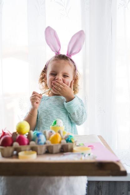 Foto gratuita niña bostezando colorear huevos
