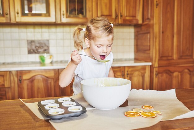 Una niña buena hornea sabrosos pastelitos