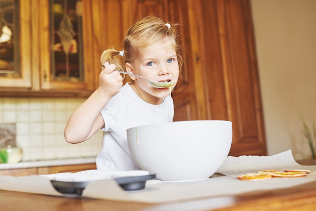 Una niña buena hornea sabrosos pastelitos