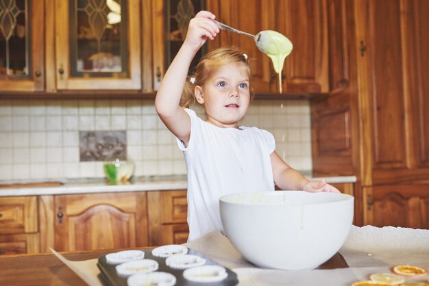 Una niña buena hornea sabrosos pastelitos