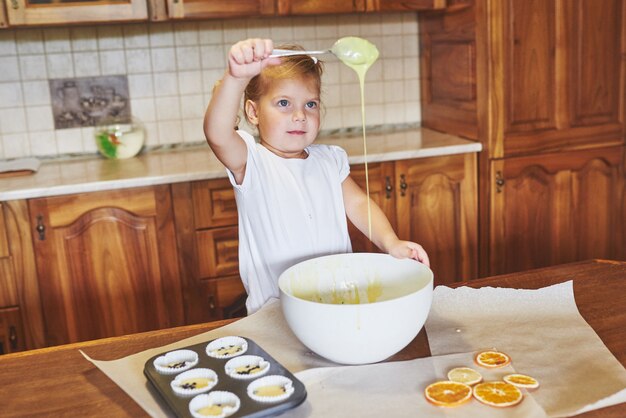 Una niña buena hornea sabrosos pastelitos