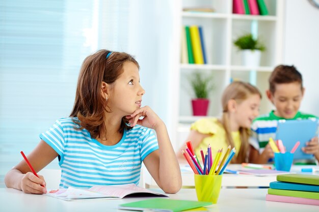 Niña buscando inspiración en el aula