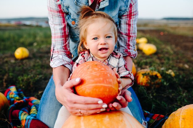 Niña con una calabaza delante de ella