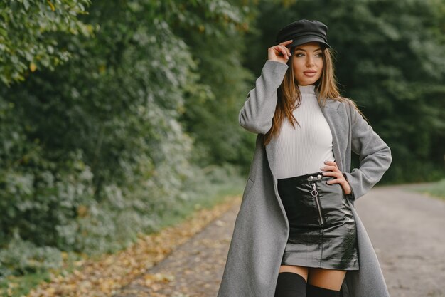 Niña camina. Mujer con un abrigo gris. Morena con gorra negra.