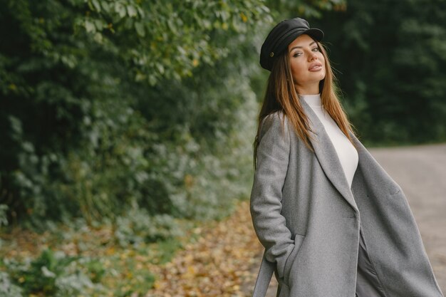 Niña camina. Mujer con un abrigo gris. Morena con gorra negra.