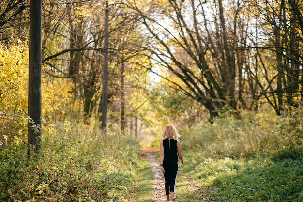 niña caminando en el parque de otoño