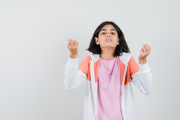 Niña en camiseta, chaqueta haciendo gesto italiano y mirando disgustado