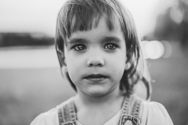 Foto gratuita niña en un campo de diente de león, al atardecer, niño feliz emocional.