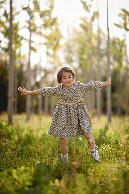 Niña en el campo de la naturaleza con vestido hermoso