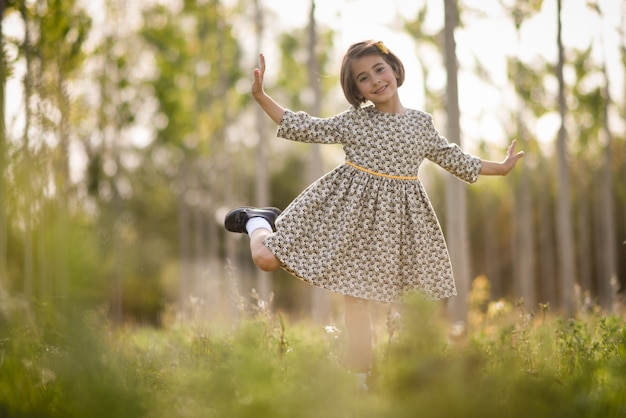 Niña en el campo de la naturaleza con vestido hermoso