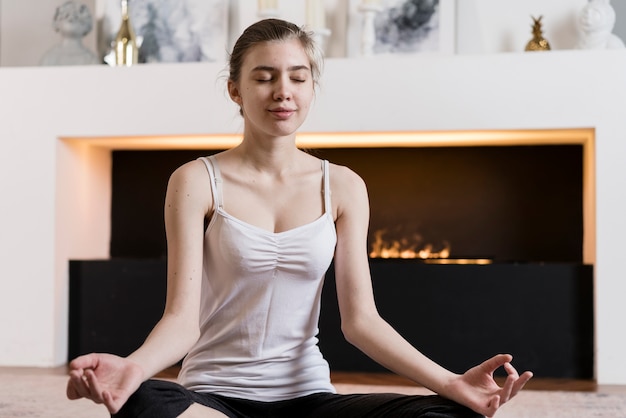 Foto gratuita niña en casa meditando