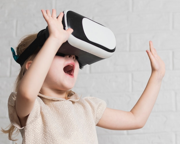 Foto gratuita niña con casco de realidad virtual