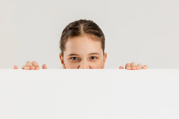 Niña caucásica aislada en la pared blanca copyspace concepto de emociones de educación infantil