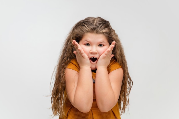 Niña caucásica feliz aislada en el fondo del estudio Se ve feliz alegre sincero Copyspace Concepto de emociones de educación infantil