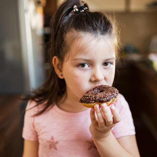 Niña con chocolate doghnout