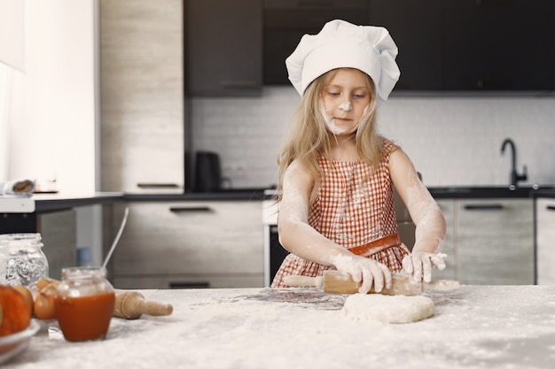 Niña cocina la masa para galletas