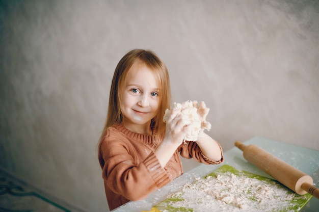 Niña cocinar la masa para galletas