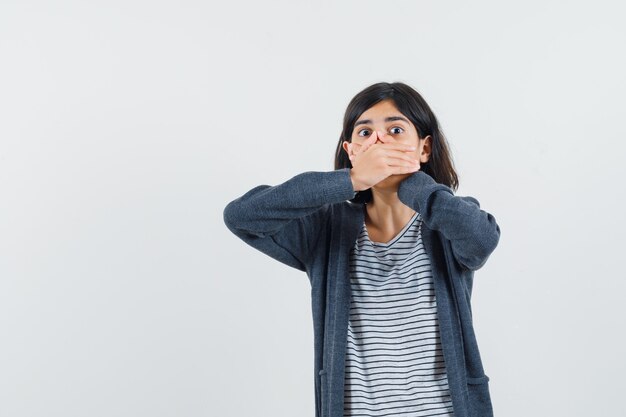 Foto gratuita niña cogidos de la mano en la boca en camiseta, chaqueta y mirando aterrorizado