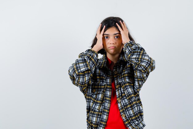 Niña cogidos de la mano en la cabeza en camisa, chaqueta, vista frontal.