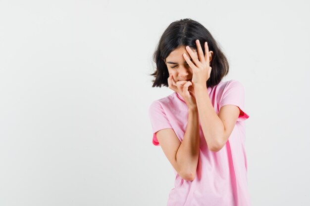 Niña cogidos de la mano en la cara con camiseta rosa y mirando asustado, vista frontal.