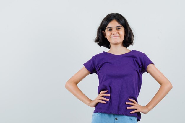 Niña cogidos de la mano en la cintura en camiseta, falda y aspecto lindo,