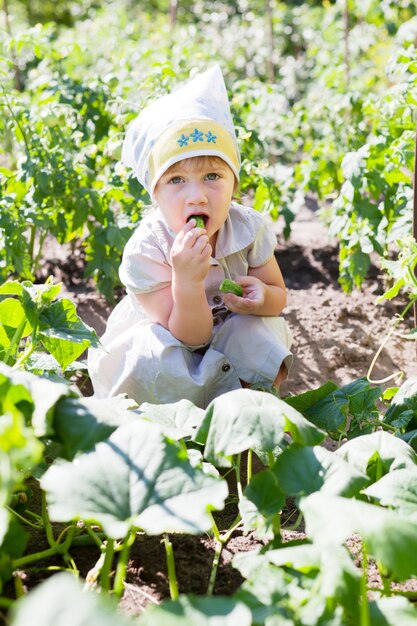 La niña come pepinos