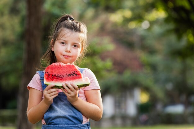 Niña comiendo sandía al aire libre