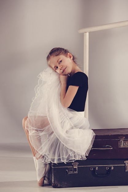 Foto gratuita la niña como bailarina de balerina sentada en el estudio