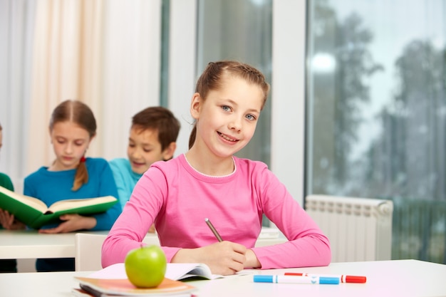 Niña concentrada escribiendo una nota