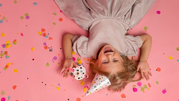 Foto gratuita niña con confeti y gorro de fiesta