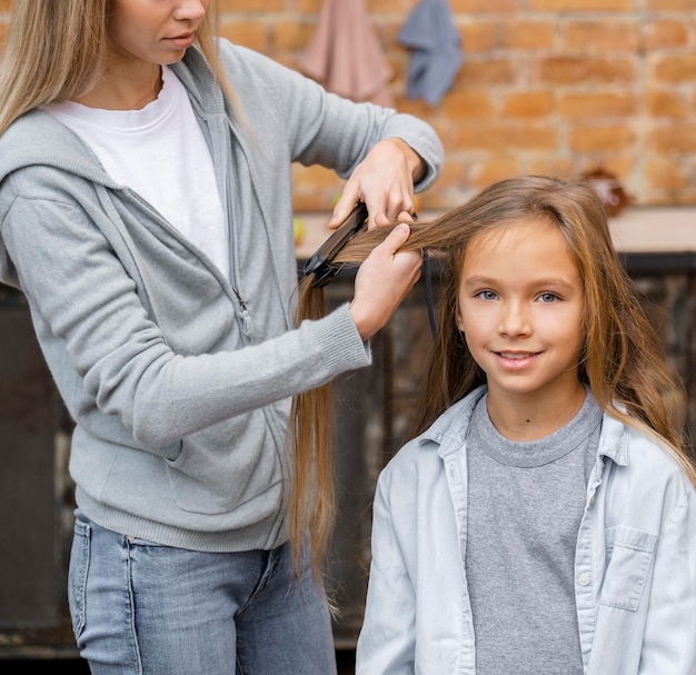 Niña conseguir su cabello alisado por peluquero