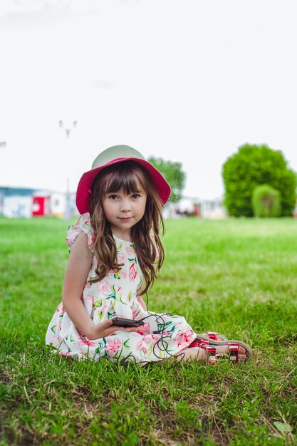 Niña contenta con un teléfono móvil en la mano