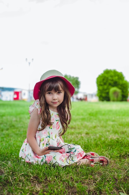 Niña contenta con un teléfono móvil en la mano