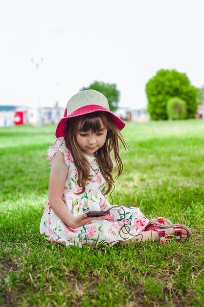 Niña contenta con un teléfono móvil en la mano