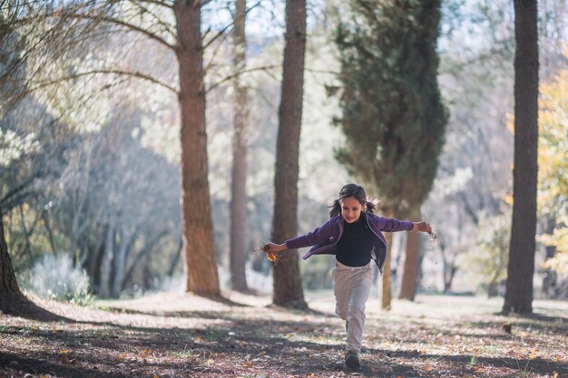 Niña corriendo en el bosque