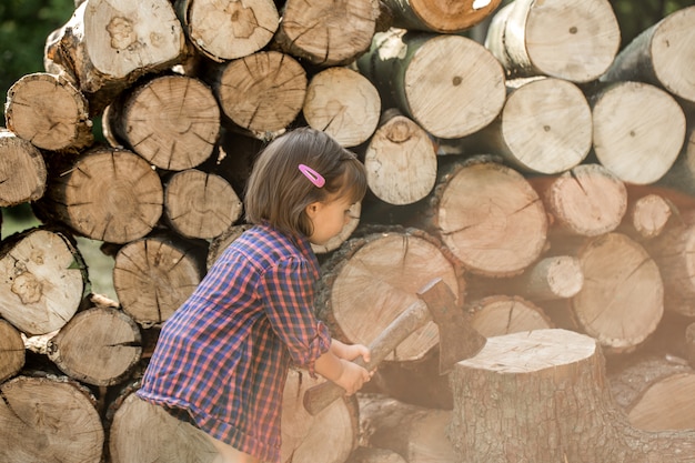 niña cortando leña