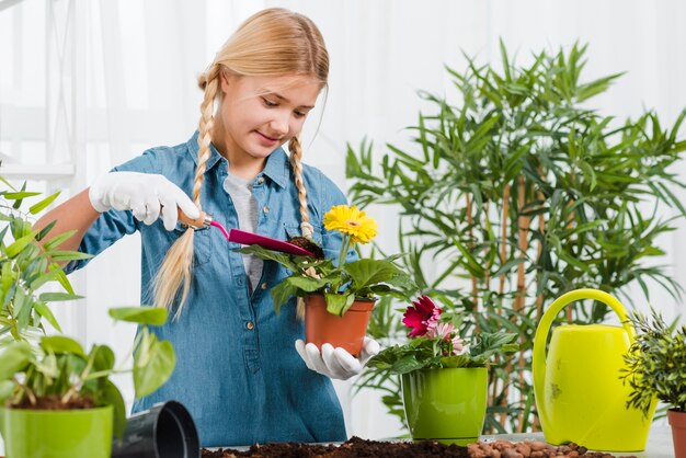 Niña cuidando flores en invernadero