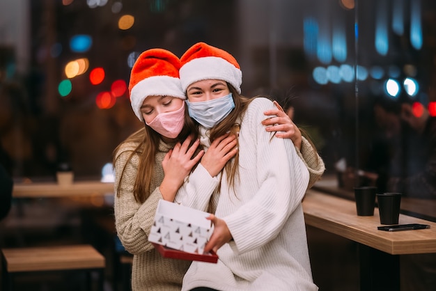 La niña le da un regalo a su amiga en caffe