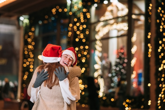 La niña le da un regalo a su amiga en la calle. Retrato de felices lindos jóvenes amigos