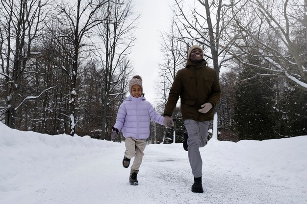 Niña dando un paseo con su padre en invierno