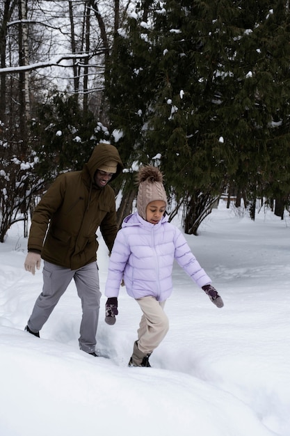 Niña dando un paseo con su padre en invierno