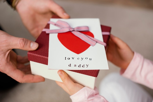 Niña dando a su padre una caja de regalo para el día del padre