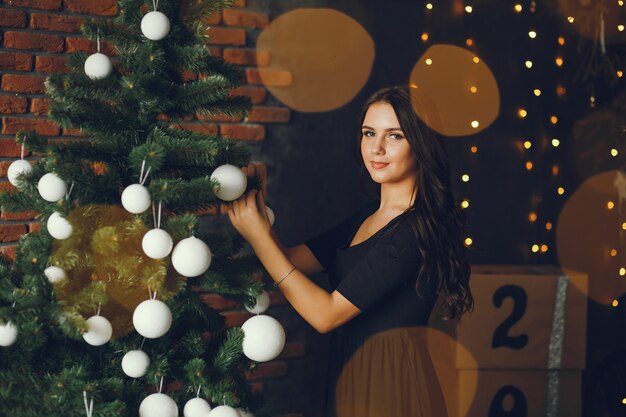 Una niña decora un árbol de navidad.