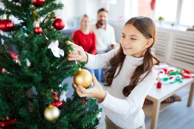 Niña decorando el árbol de Navidad