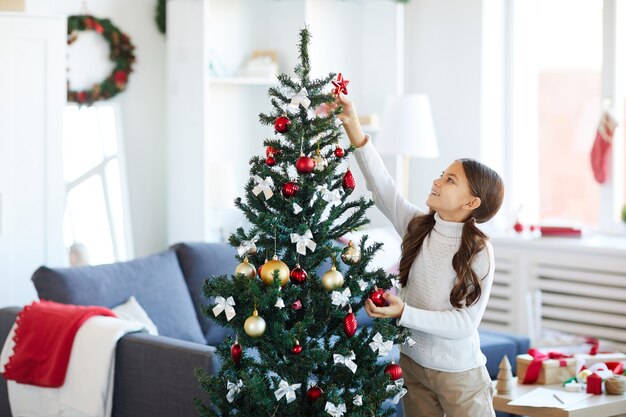 Niña decorando el árbol de Navidad