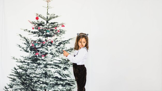 Foto gratuita niña decorando árbol de navidad